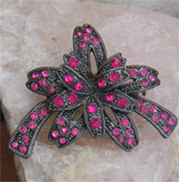 Festive vintage brooch of ribbon bow in textured metal covered with pink crystals
