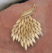 Vintage gold brooch is a spray of leaves.