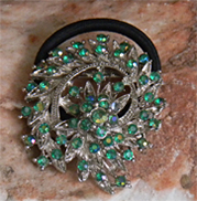 This brooch is a leaf spray covered with sparkling teal crystals.